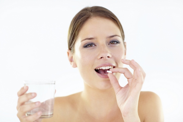 девушка пьет таблетку