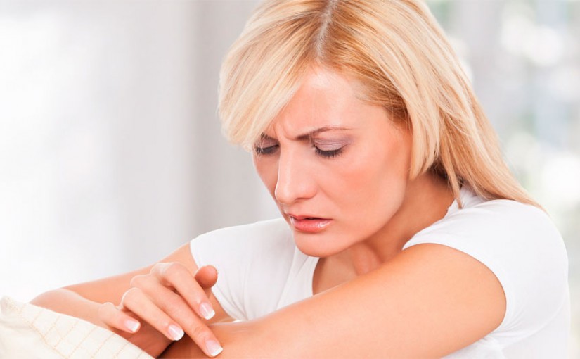 женщина смазывает кремом кожу