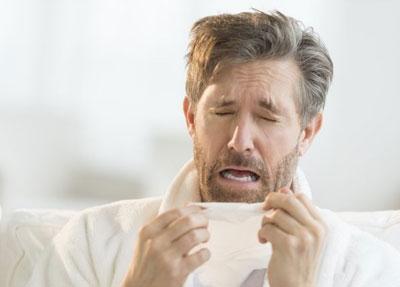 Мужчина чихает